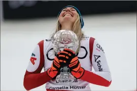  ?? PHOTOS BY ALESSANDRO TROVATI — THE ASSOCIATED PRESS ?? Austria’s Cornelia Huetter holds the women’s World Cup downhill discipline trophy after completing an alpine ski women’s World Cup downhill, in Saalbach, Austria, Saturday.