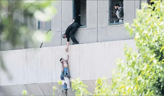  ?? GETTY IMAGES / GETTY ?? Un niño es sacado por una ventana del Parlamento iraní en plena refriega