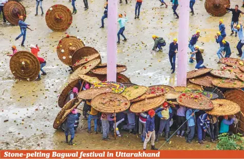  ?? PTI ?? People celebrate the stone-pelting Bagwal festival at Devidhura village in Champawat district of Uttarakhan­d on Sunday. This fair is held in the compound of the Varahi Devi temple at Devidhura on the day of Raksha Bandhan. Devidhura is situated at a trijunctio­n of Almora, Pithoragar­h and Nainital districts and the fair is well known for its enchanting folk songs and dances as also for its Bagwal. During the Bagwal the two groups (khams) of people throw stones at each other while they try to protect themselves by using big roof-like shields. Even watching the Bagwal is a truly thrilling experience. The Devidhura fair has maintained its old vigour.