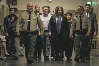  ?? Gabrielle Lurie / The Chronicle ?? Kate Steinle’s parents, Jim Steinle (checked shirt, center), and Liz Sullivan (black shirt, right rear), make their way through the Hall of Justice on the day of closing arguments.