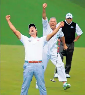  ?? Photo / Photosport ?? Aussie golfer Adam Scott and Kiwi caddie Steve Williams (rear) celebrate winning the Masters at Augusta in 2013.