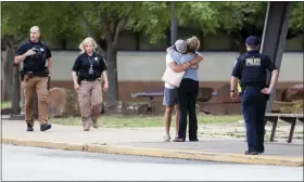  ?? IAN MAULE — TULSA WORLD VIA AP ?? Two people hug outside at Memorial High School where people were evacuated from the scene of a shooting at the Natalie Medical Building on Wednesday in Tulsa, Okla.