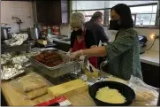  ?? ?? From left, Lynne West, Robby Dimacchia and Heidi Gedling prepare the meals Oct. 9 for the Italian American Veterans Post 1annual Festa Italiana in Lorain.