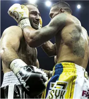  ??  ?? SPORTING GREAT: Usyk addresses his rival [above]; receives all the belts in the division as Lonnie Ali presents him with the Muhammad Ali Trophy [above right]; and ˆnally the Ukrainian can celebrate with his entire team [right] in Moscow