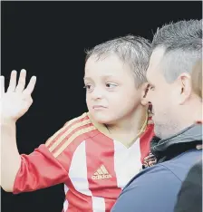  ??  ?? Bradley waves to fans with dad Carl .