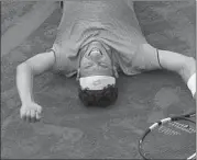  ?? MICHEL EULER/AP ?? Marco Cecchinato, ranked No. 72 in the world, lays on the clay after his win over Novak Djokovic on Tuesday in Paris.