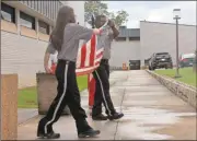  ??  ?? Top and left: City police officers and Cedartown Police Explorers prepaer a flag for official retirement and ceremonial burning during a July 11 ceremony. Right: Dalton Myers of Cedartown High School played taps for the ceremony.