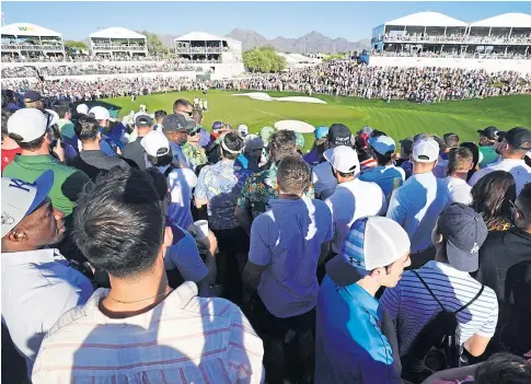  ?? ?? ROWDY: Fans crowd the 18th hole during the third round of the Waste Management Phoenix Open at the weekend.