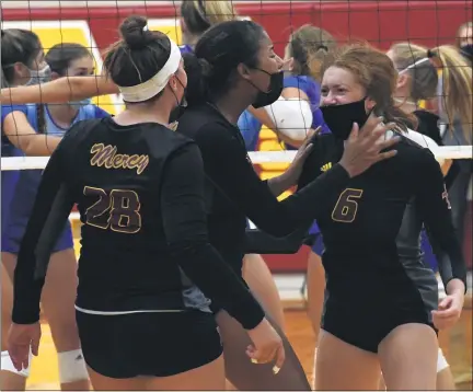  ?? PHOTOS BY DREW ELLIS — MEDIANEWS GROUP ?? Mercy’s Julia Bishop (left) and Charli Atiemo (middle) celebrate with teammate Leah LaFontaine after she scores a block during Monday’s match with Birmingham Marian. The Marlins swept the Mustangs, 25-22, 25-22, 27-25.