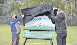  ?? DIANE CROCKER • THE TELEGRAM ?? With a toss of the cover the new sign for the Doug Sweetapple Soccer Field on Wellington Street in Corner Brook was unveiled by Mayor Jim Parsons (left) and Sweetapple during a naming ceremony on Tuesday.