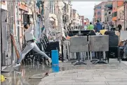  ?? [ANDREA MEROLA/ANSA VIA THE ASSOCIATED PRESS] ?? A woman jumps over a puddle Thursday during cleaning following flooding in Venice, Italy.