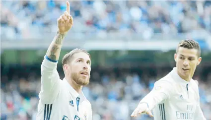  ??  ?? Sergio Ramos, defensa del Real Madrid, celebra junto a su compañero de equipo Cristiano Ronaldo, tras anotar un gol en el partido de ayer contra el Málaga en el estadio Santiago Bernabeu stadium, en Madrid.