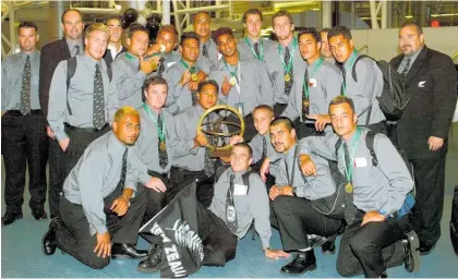  ?? Photos / Getty Images ?? Members of the 2004 New Zealand Under-19 rugby team celebrate with the trophy on returning home from South Africa.