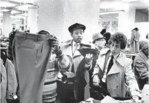  ?? WILLIAM YATES/CHICAGO TRIBUNE ?? A crowd gathers at the garment racks at the Goldblatt Bros. store during a menswear sale on Oct. 16, 1978.