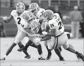  ?? Curtis Compton Associated Press ?? GEORGIA defenders, from left, Richard LeCounte, DJ Daniel, Monty Rice and Quay Walker, tackle Florida wide receiver Tyrie Cleveland.