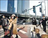  ?? REUTERS ?? People walk during morning rush hour, following the outbreak of Covid-19, in Chaoyang district, Beijing, on Monday.