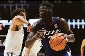  ?? Dylan Buell / Getty Images ?? UConn’s Adama Sanogo dribbles the ball while being guarded by Xavier’s Colby Jones at the Cintas Center on Saturday in Cincinnati, Ohio.