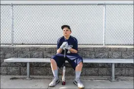  ?? PHOTOS BY LAUREN JUSTICE / THE NEW YORK TIMES ?? John Zeamer, 10, sits in the dugout in Waupaca, Wis., with his new USA Baseballap­proved bat. Prices are running anywhere from $45 to $350 for bats. Zeamer’s cost $250.