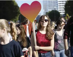  ??  ?? A protester holds a giant heart-shaped placard as she takes part in a major demonstrat­ion yesterday for an open and caring society organised by the action group ‘unteilbar’ (‘Indivisibl­e’) in Berlin.