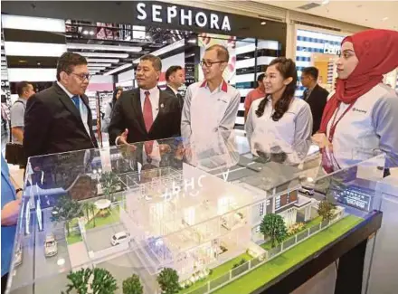  ?? PIC BY MOHD AZREN JAMALUDIN ?? NSTP chief executive officer Datuk Seri Abdul Jalil Hamid (left) and Johor Housing and Rural Developmen­t Committee chairman Dzulkefly Ahmad (second from left) being briefed by Huayang Bhd assistant branch manager Wong Wai Hong (third from right) at...