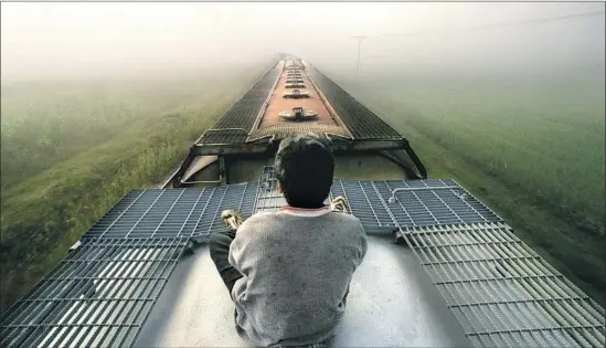  ?? Don Barletti Los Angeles Times ?? IN “DIRT,” a mother and son f lee toward the U.S. partly atop a freight train, like the Honduran boy shown in this 2003 Pulitzer Prize-winning photograph.