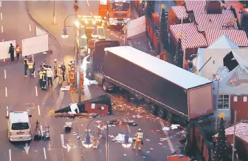  ??  ?? This file photo shows forensic experts examining the scene around a truck that crashed into a Christmas market in Berlin. — AFP photo