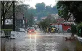  ?? FOTO: MARTIN WICHMANN/DPA ?? Einsatzfah­rzeuge stehen in Plaue an einer vom Wasser überflutet­en Straße. Dutzende Keller liefen durch Tief „Axel“voll.