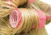  ?? DREAMSTIME ?? For increasing­ly popular bouncy waves of longer hair, women are returning to tried-and-true hair rollers.