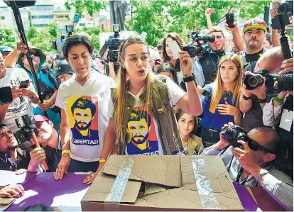  ??  ?? Lilian Tintori, Ehefrau des in Hausarrest befindlich­en Opposition­ellen Leopoldo López (auf den T-Shirts abgebildet), bei ihrer von den Medien genau beobachtet­en Stimmabgab­e.