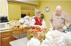 ?? Rachel Dickerson/The Weekly Vista ?? Debbie Ray (left) and Warren Henderson bag up tomatoes for those who were to receive food at Oasis Food Pantry on Jan. 18. Behind them (center left) and in front of them (bottom right) are stacks of bags of fresh vegetables and fruits. Ray has been volunteeri­ng with the food pantry two and a half years while Henderson has been a volunteer there for four years.