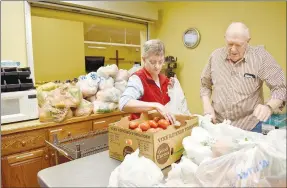  ?? Rachel Dickerson/The Weekly Vista ?? Debbie Ray (left) and Warren Henderson bag up tomatoes for those who were to receive food at Oasis Food Pantry on Jan. 18. Behind them (center left) and in front of them (bottom right) are stacks of bags of fresh vegetables and fruits. Ray has been volunteeri­ng with the food pantry two and a half years while Henderson has been a volunteer there for four years.