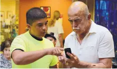  ?? COURTESY OF TEENIORS ?? Joe Lucero, 14, helps a senior with his smartphone at a Teeniors event at the Barelas Senior Center. Teeniors, Comcast Corp. and Adelante join forces to educate seniors about online safety.