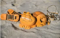  ??  ?? Spare parts of plastic ‘Garfield’ phones are displayed on the beach in Plouarzel, western France, after being collected from a sea cave by environmen­tal activists. — AFP photo