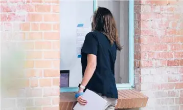  ?? ROSS D. FRANKLIN/AP ?? Pima County Constable Kristen Randall signs an eviction notice last month in Tucson, Arizona.