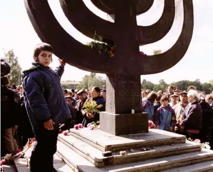  ??  ?? FIGHT OVER memory. A Jewish boy stands by a memorial at Baby Yar in Kiev in 1996.