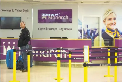  ?? Oli Scarff / AFP / Getty Images ?? A passenger waits in the Birmingham Airport in England after British carrier Monarch Airlines ceased operations.