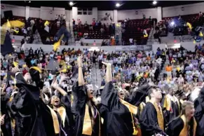  ?? SDN) (Photo by Olivia Zeringue, ?? Starkville High School graduates throw their caps in the air following the school's graduation ceremony Friday night at Humphrey Coliseum