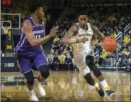  ?? TONY DING - THE ASSOCIATED PRESS ?? Northweste­rn guard Anthony Gaines (11) defends Michigan guard Charles Matthews, right, in the second half of an NCAA college basketball game in Ann Arbor, Mich., Sunday, Jan. 13, 2019. Michigan won 80-60.