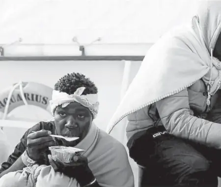  ?? Foto: Efe ?? La hora de la comida para dos inmigrante­s en la cubierta del ‘Aquarius’.