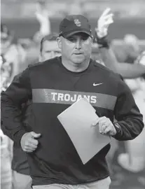  ?? TIMOTHY J. GONZALEZ/AP ?? Southern California head coach Clay Helton leads his team onto the field before an NCAA college football game in Corvallis, Ore.