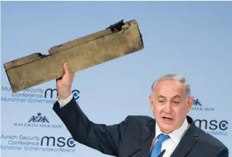  ??  ?? Israeli Prime Minister Benjamin Netanyahu holds up a remnant of what he said was a piece of Iranian drone shot down in Israeli airspace.