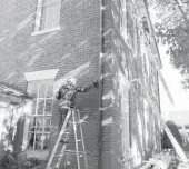  ?? MARK REED / CITY OF VIRGINIA BEACH ?? Landmark Preservati­on employees work on the Princess Anne County Courthouse’s “red wash” makeover Nov. 19.