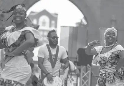  ?? KASSI JACKSON PHOTOS/HARTFORD COURANT ?? Mellissa Craig, right, of Hartford, dances with FriendzWor­ldMusic as the group performs during the Juneteenth celebratio­n Saturday at Hartford’s Black Lives Matter mural on Trinity Street near Bushnell Park.