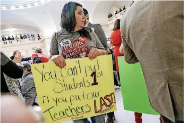  ?? [PHOTO BY CHRIS LANDSBERGE­R, THE OKLAHOMAN] ?? Locust Grove teacher Julie Atchley carries a sign during a rally at the state Capitol in Oklahoma City in February. Oklahoma public school teachers say they will walk off the job April 2 if legislator­s don’t have a plan in place to give them raises.