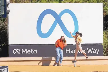  ?? TONY AVELAR/ASSOCIATED PRESS ?? Facebook employees take a photo with the company’s new name and logo outside its headquarte­rs in Menlo Park, Calif. Facebook Inc. announced Thursday it was changing its name to Meta Platforms Inc.