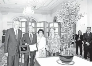  ?? - GambarBERN­AMA ?? PERDANA Menteri Tun Dr Mahathir Mohamad (dua, kiri) bersama isteri Tun Dr Siti Hasmah Mohamad Ali (tiga, kiri) diiringi Perdana Menteri Singapura Lee Hsien Loong (kiri) dan isteri Ho Ching (tiga, kanan) bergambar dengan Orkid yang diberi nama ‘Dendrobium Mahathir Siti Hasmah’ sempena kunjungann­ya ke Singapura pada Lawatan Rasmi di The Istana pada Isnin.