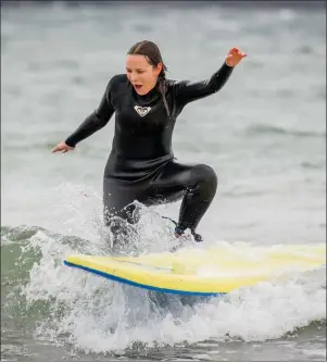  ??  ?? A foreign journalist attempts to catch a wave in Strandhill while on a press tour of Sligo with Failte Ireland. The jounalists have a combined audience of 12 million people
