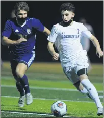  ??  ?? Rochester’s Carlito Ankawi (7) moves past Stoney Creek’s Riley Lamendola during the MHSAA D1pre-district match held on Wednesday at Stoney Creek High School. Ankawi had the lone Falcon goal, as they fell to the Cougars 2-1in overtime.