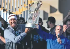  ?? - Associated
Press: Orlin Wagner ?? Le receveur Salvador Perez et le directeur général des Royals de Kansas City Dayton Moore ont présenté à la foule le trophée des champions de la Série mondiale.