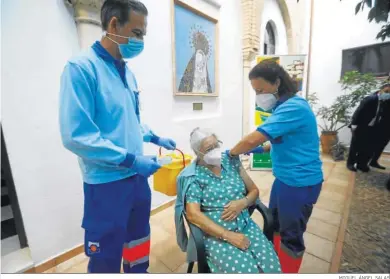  ?? MIGUEL ÁNGEL SALAS ?? Dos sanitarios ponen la vacuna de la gripe a la usuaria de una residencia, ayer en Córdoba.